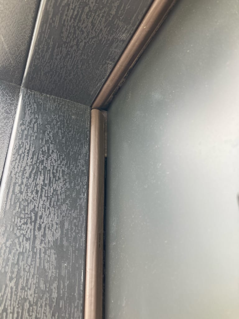 The weatherstrip at the top corner of the opening, where the slab should seal when the door is closed. UTS ServicePros field photo.